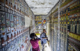 This picture taken on April 13, 2019 shows journalists filming inside the newly-dicovered tomb of the ancient Egyptian nobleman "Khewi" dating back to the 5th dynasty (2494–2345 BC), at the Saqqara necropolis, about 35 kilometres south of the capital Cairo. Mohamed el-Shahed / AFP