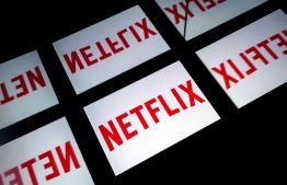 (FILES) In this file photo taken on February 18, 2019 This illustration picture shows the US Online Streaming giant Netflix logo displayed on a tablet in Paris. - It may already have Oscars under its belt, but Netflix's acceptance by the Academy of Motion Picture Arts and Sciences hangs in the balance. The prestigious body is set to reexamine whether the streaming giant will remain eligible for such awards, despite a warning from the US Justice Department that could violate antitrust laws. (Photo by Lionel BONAVENTURE / AFP)