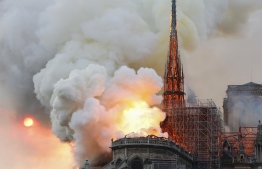 Smoke and flames rise during a fire at the landmark Notre-Dame Cathedral in central Paris on April 15, 2019, potentially involving renovation works being carried out at the site, the fire service said. - A major fire broke out at the landmark Notre-Dame Cathedral in central Paris sending flames and huge clouds of grey smoke billowing into the sky, the fire service said. The flames and smoke plumed from the spire and roof of the gothic cathedral, visited by millions of people a year, where renovations are currently underway. (Photo by FRANCOIS GUILLOT / AFP)