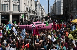 Environmental protesters from the Extinction Rebellion group gather around a pink boat as they take part in a demonstration at the junction of Oxford Street and Regent Street in London on April 15, 2019. - Environmental protesters from the Extinction Rebellion campaign group started a programme of demonstrations designed to block five of London's busiest and iconic locations to draw attention to what they see as the "Ecological and Climate Emergency" of climate change. (Photo by Daniel LEAL-OLIVAS / AFP)