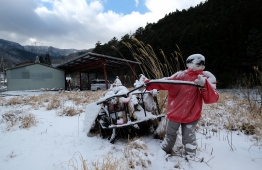 This picture taken on March 16, 2019 shows life-size doll depicting a scarecrow pulling a cart in the tiny village of Nagoro in western Japan. - In the tiny village of Nagoro, deep in the mountains of western Japan, the wind howls down a deserted street with not a living soul to be seen. But yet the street appears busy, dotted with life-sized dolls that outnumber humans 10 to one, the product of a one-woman bid to counter the emptiness and loneliness felt in Nagoro, like many Japanese villages decimated by depopulation. PHOTO: KAZUHIRO NOGI / AFP