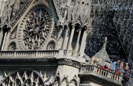 Firefighters and technicians work on a balcony of Notre-Dame de Paris Cathedral in Paris on April 19, 2019, four days after a fire devastated the cathedral. - Thousands of Parisians and tourists watched in horror from nearby streets on April 15 as flames engulfed the building and rescuers tried to save as much as they could of the cathedral's treasures built up over centuries. (Photo by Lionel BONAVENTURE / AFP)