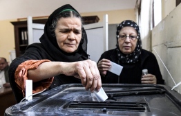 Elderly Egyptian women cast their ballots in a box as they vote at a polling station in a referendum on constitutional amendments, at a school in the capital Cairo's northern neighbourhood of Shubra, on the first day of a three-day poll, on April 20, 2019. Polls in Egypt opened on April 20 for 62 million eligible voters to make their voice hear on a referendum that could keep President Abdel Fattah al-Sisi in power until 2030. On the ballot is a raft of constitutional changes that would extend Sisi’s current term by two years. He would be eligible to run for six more years in 2024. PHOTO/AFP
