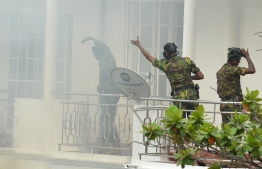 Sri Lankan Special Task Force (STF) personnel gesture outside a house during a raid -- after a suicide blast had killed police searching the property -- in the Orugodawatta area of the capital Colombo on April 21, 2019, following a series of blasts in churches and hotels. - A string of blasts ripped through high-end hotels and churches holding Easter services in Sri Lanka on April 21, killing at least 156 people, including 35 foreigners. (Photo by ISHARA S. KODIKARA / AFP)