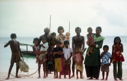 Gayle and Dhonkokko pictures with islanders on the beach. PHOTO: FRANK BURNABY