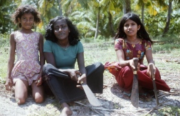 Maldivian girls pictured with kathi valhi (a strong knife used in everyday activities such as collecting firewood). PHOTO: FRANK BURNABY