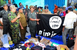 In this picture taken on April 26, 2019, security personnel inspects seized items after they raid what believed to be an Islamist safe house in the eastern town of Kalmunai. - Fifteen people, including six children, died during a raid by Sri Lankan security forces as three cornered suicide bombers blew themselves up and others were shot dead, police said on April 27. (Photo by STRINGER / AFP)