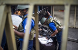 Sri Lankan soldiers inspect a car at a checkpoint in Colombo on April 27, 2019, following a series of bomb blasts targeting churches and luxury hotels on Easter Sunday in Sri Lanka. - Fifteen people including six children have died during a Sri Lankan security forces operation in the aftermath of the Easter attacks, as three cornered suicide bombers blew themselves up and others were shot dead, police said on April 27. (Photo by Jewel SAMAD / AFP)