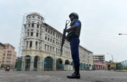 A Sri Lankan Navy personnel guards a road blocked near the port in Colombo on April 27, 2019, following a series of bomb blasts targeting churches and luxury hotels on Easter Sunday in Sri Lanka. - Fifteen people including six children have died during a Sri Lankan security forces operation in the aftermath of the Easter attacks, as three cornered suicide bombers blew themselves up and others were shot dead, police said on April 27. (Photo by ISHARA S. KODIKARA / AFP)