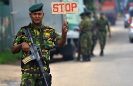 A Sri Lankan Special Task Force (STF) soldier stops a vehicle in Colombo on April 27, 2019, following a series of bomb blasts targeting churches and luxury hotels on Easter Sunday in Sri Lanka. - Fifteen people including six children have died during a Sri Lankan security forces operation in the aftermath of the Easter attacks, as three cornered suicide bombers blew themselves up and others were shot dead, police said on April 27. (Photo by ISHARA S.  KODIKARA / AFP)