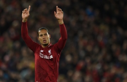 Liverpool's Dutch defender Virgil van Dijk acknowledges supporters  during the English Premier League football match between Liverpool and Huddersfield at Anfield in Liverpool, north west England on April 26, 2019. (Photo by Oli SCARFF / AFP) / RESTRICTED TO EDITORIAL USE. No use with unauthorized audio, video, data, fixture lists, club/league logos or 'live' services. Online in-match use limited to 120 images. An additional 40 images may be used in extra time. No video emulation. Social media in-match use limited to 120 images. An additional 40 images may be used in extra time. No use in betting publications, games or single club/league/player publications. / 