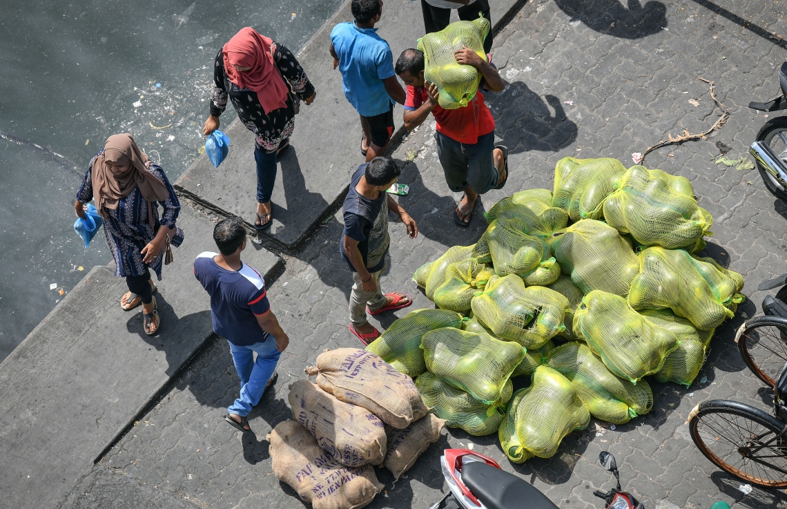 މާލެ: މޭ 5، 2019- ވަޅޯމަސް މާރުކޭޓު ސަރަހައްދުގައި ބަޔަކު ކަރާ އުފުލާއިރު، ރޯދަ އަށް ބާޒާރު ކުރަން ނުކުތް ބަޔަކު ހިނގާފައި ދަނީ.---ފޮޓޯ: ނިޝާން އަލީ/މިހާރު