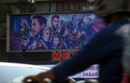 (FILES) In this file photo taken on April 25, 2019, Indian vehicles go past a movie theatre displaying a poster of the latest Avengers movie, in Mumbai. - "Avengers: Endgame" led the North American box office for a third week running, but the cuddly creatures of a new "Pokemon" movie gave the superheroes a run for its money, industry watchers said on May 12, 2019. (Photo by Indranil MUKHERJEE / AFP)