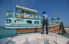 A Maldivian police officer beside the Iranian vessel intercepted in Maldivian waters. PHOTO: NISHAN ALI/MIHAARU