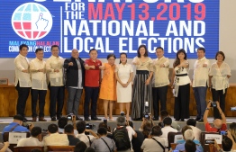 Philippines' Senators-elect, and allies of President Rodrigo Duterte, show the Duterte fist, (L-R) movie actor Bong Revilla, Francis Tolentino, movie actor Lito lapid, former national police chief Ronald dela Rosa, long-time advisor of Duterte, Christopher Bong Go, Cynthia Villar, Pia Cayetano, Sonny Angara, Imee Marcos, daughter of the late dictator Ferdinand Marcos, Aquilino Koko Pimentel III, while Independent candidates Grace Poe (6th R) and Nancy Binay (R) stand during the proclamation ceremony by the Commission on elections in Manila on May 22, 2019. - Allies of President Rodrigo Duterte stormed to a landslide victory in midterm polls, final results showed Masy 22, dissolving a last bulwark against his controversial rule. (Photo by Ted ALJIBE / AFP)