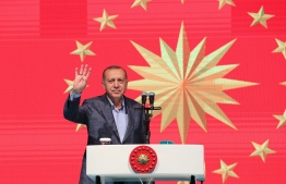 This handout picture released by the Turkish President's press office on May 12, 2019 shows Turkish President Recep Tayyip Erdogan flashes four fingers and makes the Rabia sign as he speaks during holy month of Ramadan, at Istiklal Avenue in Istanbul. (Photo by - / TURKISH PRESIDENTIAL PRESS SERVICE / AFP) / 