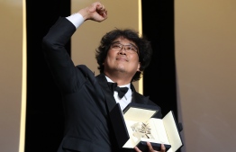 South Korean director Bong Joon-Ho celebrates on stage with his trophy after he was awarded with the Palme d'Or for the film "Parasite (Gisaengchung)" on May 25, 2019 during the closing ceremony of the 72nd edition of the Cannes Film Festival in Cannes, southern France. (Photo by Valery HACHE / AFP)