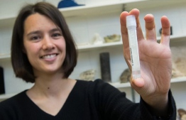 Assistant Professor Clara Blättler with a vial of seawater dating to the last Ice Age—about 20,000 years ago. PHOTO: Jean Lachat