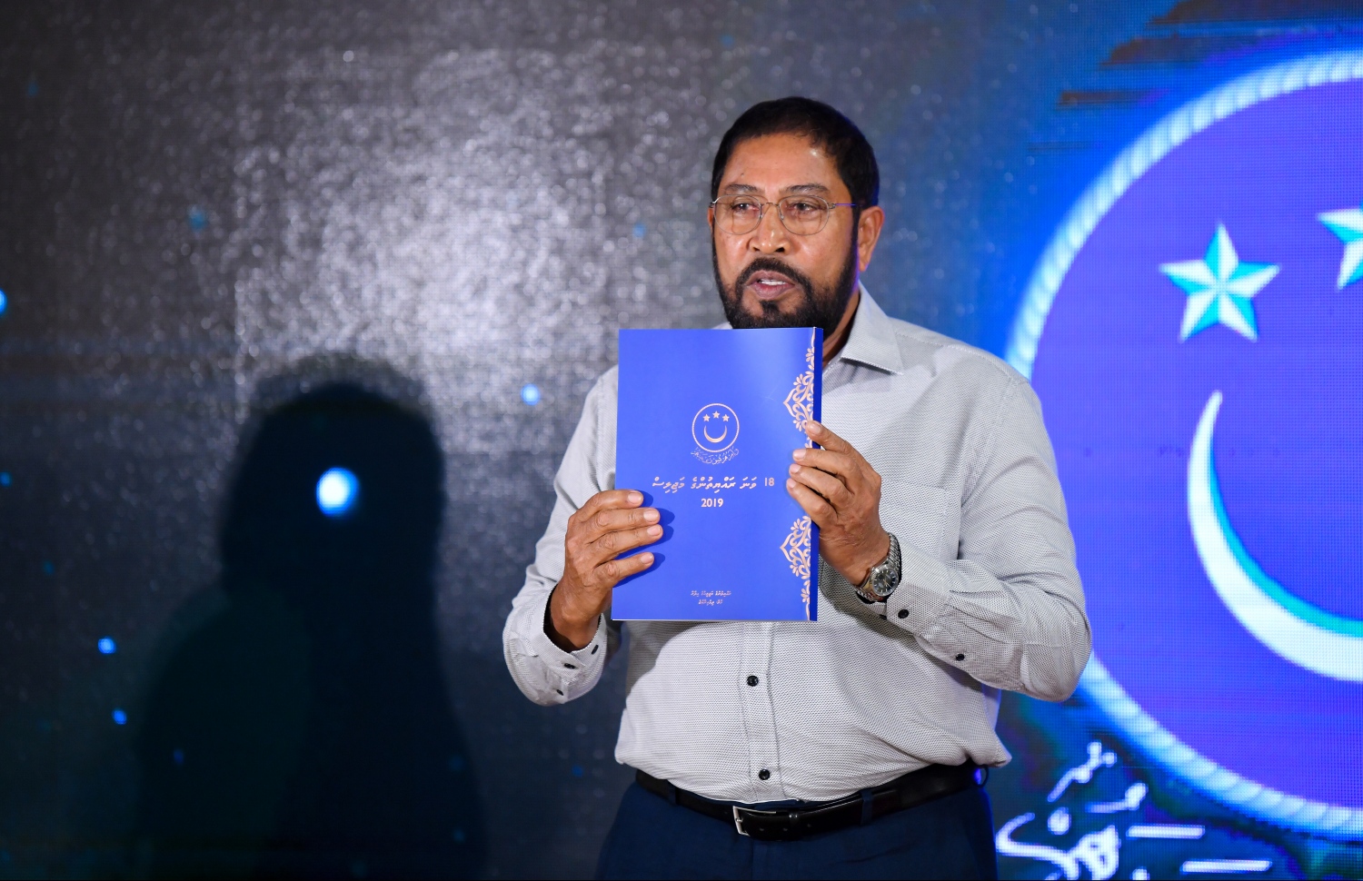 18 ވަނަ މަޖިލިހުގެ މަސައްކަތްތަކާ ބެހޭ ގޮތުން ތައްޔާރު ކުރި ފޮތް މަޖިލިހުގެ ރައީސް ގާސިމް ނެރެދެއްވަނީ. --- ފޮޓޯ: ހުސެއިން ވަހީދު/ މިހާރު