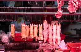 Pig trotters hang inside a meat stall after pork meat sold out in the Mong Kok district in Hong Kong on June 1, 2019. - Hong Kong will cull 4,700 pigs after African swine fever was detected in an animal at a slaughterhouse close to the border with China, the second such case in a month in the crowded financial hub. (Photo by Philip FONG / AFP)