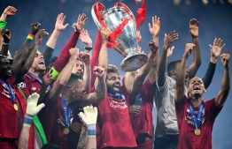 Liverpool's Egyptian forward Mohamed Salah (C) raises the European Champion Clubs' Cup as he celebrates with teammates winning the UEFA Champions League final football match between Liverpool and Tottenham Hotspur at the Wanda Metropolitano Stadium in Madrid on June 1, 2019. (Photo by GABRIEL BOUYS / AFP)