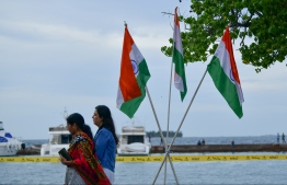 Two Indian walk past their national flags in the capital Male' during the visit of Indian Prime Minister Narendra Modi. -- PHOTO: MIHAARu