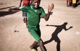 A child plays after a psychological support session for children with Post Traumatic Stress Disorder at the Lazare camp for internally displaced people (IDP) in Kaga Bandoro on May 23, 2019. - In the northern part of the country devastated by the crisis, the International Red Cross has set up a workshop to detect and treat Post Traumatic Stress Disorder through drawing. (Photo by FLORENT VERGNES / AFP)