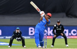 Afghanistan's Hazratullah Zazai plays a shot during the 2019 Cricket World Cup group stage match between Afghanistan and New Zealand at The County Ground in Taunton, southwest England, on June 8, 2019. - New Zealand's Colin de Grandhomme (R) drops a possible catch off Afghanistan's  Hazrat Zazai (Photo by Saeed KHAN / AFP) / 
