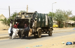 Municipality workers clean up the streets in the Sudanese capital Khartoum on June 12, 2019. - Shops began to reopen in Sudan's capital but many residents stayed indoors even as demonstrators called off a nationwide civil disobedience campaign launched after a deadly crackdown in Khartoum killed dozens. As a breakthrough came after mediations led by Ethiopian Prime Minister Abiy Ahmed, who visited Khartoum last week, the United Nations Security Council called on the ruling generals and protest leaders to resolve the crisis triggered by the June 3 crackdown on protesters. (Photo by - / AFP)