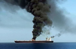 A picture obtained by AFP from Iranian State TV IRIB on June 13, 2019 reportedly shows smoke billowing from a tanker said to have been attacked off the coast of Oman, at un undisclosed location. - The crews of two oil tankers were evacuated off the coast of Iran today after they were reportedly attacked and caught fire in the Gulf of Oman, sending world oil prices soaring. The mystery incident, the second involving shipping in the strategic sea lane in only a few weeks, came amid spiralling tensions between Tehran and Washington, which has pointed the finger at Iran over tanker attacks in May. Iran said its navy had rescued 44 crew members after the two vessels caught fire in "accidents" off its coast. (Photo by HO / IRIB TV / AFP) / == RESTRICTED TO EDITORIAL USE - MANDATORY CREDIT "AFP PHOTO / HO / IRIB" - NO MARKETING NO ADVERTISING CAMPAIGNS - DISTRIBUTED AS A SERVICE TO CLIENTS FROM ALTERNATIVE SOURCES, AFP IS NOT RESPONSIBLE FOR ANY DIGITAL ALTERATIONS TO THE PICTURE'S EDITORIAL CONTENT, DATE AND LOCATION WHICH CANNOT BE INDEPENDENTLY VERIFIED - NO RESALE -NO ACCESS lSRAEL MEDIA -PERSIAN LANGUAGE TV STATIONS OUTSIDE IRAN - STRICTLY NO ACCESS BBC PERSIAN  == / 