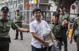 Hong Kong democracy activist Joshua Wong (C) leaves Lai Chi Kok Correctional Institute in Hong Kong on June 17, 2019. - Wong called on the city's pro-Beijing leader Carrie Lam to resign after he walked free from prison, as historic anti-government protests rocked the city. (Photo by ISAAC LAWRENCE / AFP)