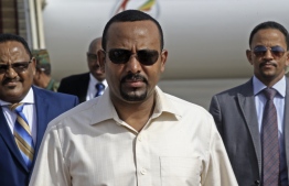 (FILES) In this file photo taken on June 07, 2019 Ethiopia's Prime Minister Abiy Ahmed (C) arrives at Khartoum international airport on June 7, 2019. - Ethiopia's Prime Minister Abiy Ahmed said on June 22, 2019 that the army chief of staff had been shot, however his condition was unknown after an evening of unrest in the Horn of Africa nation. (Photo by ASHRAF SHAZLY / AFP)