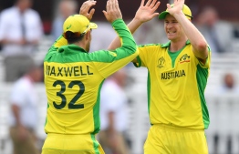 Australia's Jason Behrendorff (R) celebrates with teammate Glenn Maxwell after victory in the 2019 Cricket World Cup group stage match between England and Australia at Lord's Cricket Ground in London on June 25, 2019. (Photo by SAEED KHAN / AFP) / 