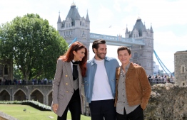 Actors Zendaya (L), Jake Gyllenhaal (C) and Tom Holland pose during a photocall for their latest film 'Spider-Man: Far From Home' at the Tower of London, backdropped by London's Tower Bridge, in London on June 17, 2019. (Photo by ISABEL INFANTES / AFP)