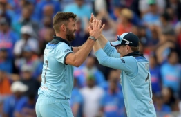 England's Liam Plunkett (L) celebrates with captain Eoin Morgan after the dismissal of India's Hardik Pandya during the 2019 Cricket World Cup group stage match between England and India at Edgbaston in Birmingham, central England, on June 30, 2019. (Photo by Dibyangshu Sarkar / AFP) / 