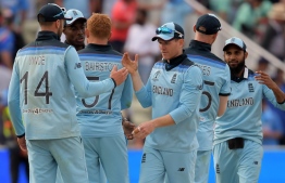 England's captain Eoin Morgan (C) celebrates with his players after victory in the 2019 Cricket World Cup group stage match between England and India at Edgbaston in Birmingham, central England, on June 30, 2019. (Photo by Dibyangshu Sarkar / AFP) / 