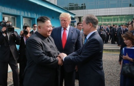 This picture taken on June 30, 2019 and released by North Korea's official Korean Central News Agency (KCNA) on July 1, 2019 shows North Korea's leader Kim Jong Un (L) meeting South Korea's President Moon Jae-in (R) and US President Donald Trump (C) on the south side of the Military Demarcation Line that divides North and South Korea, in the Joint Security Area (JSA) of Panmunjom in the Demilitarized zone (DMZ). (Photo by KCNA VIA KNS / KCNA VIA KNS / AFP) / South Korea OUT / REPUBLIC OF KOREA OUT   ---EDITORS NOTE--- RESTRICTED TO EDITORIAL USE - MANDATORY CREDIT "AFP PHOTO/KCNA VIA KNS" - NO MARKETING NO ADVERTISING CAMPAIGNS - DISTRIBUTED AS A SERVICE TO CLIENTS / THIS PICTURE WAS MADE AVAILABLE BY A THIRD PARTY. AFP CAN NOT INDEPENDENTLY VERIFY THE AUTHENTICITY, LOCATION, DATE AND CONTENT OF THIS IMAGE --- / 