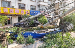 This photo taken on July 3, 2019 shows fallen telegraph poles damaged by a tornado in Kaiyuan, in China's northeastern Liaoning province. - A tornado has left six people dead and nearly 200 injured after ripping through a northeastern Chinese city, local authorities said on July 4. (Photo by STR / AFP) / 