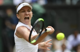 Romania's Simona Halep returns against Ukraine's Elina Svitolina during their women's singles semi-final match on day ten of the 2019 Wimbledon Championships at The All England Lawn Tennis Club in Wimbledon, southwest London, on July 11, 2019. (Photo by Daniel LEAL-OLIVAS / AFP) / 