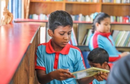 A student choosing a book in the newly opened Maaenboodhoo School library, funded by Bank of Maldives' (BML) community fund. PHOTO: BML