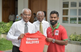 Badminton player Ajfaan giving a jersey to  President Ibrahim Mohamed Solih. PHOTO: PRESIDENTS OFFICE