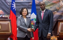 Taiwan's President Tsai Ing-wen and Haiti's President Jovenel Moise shake hands during a state visit in Port-au-Prince on July 13, 2019. - Taiwan President Tsai Ing-wen's choice of Port-au-Prince as the first stop in her Caribbean tour is highly symbolic of the diplomatic power struggle being played out in the region. Last year, the neighboring Dominican Republic dropped Taipei and threw in its diplomatic lot with Beijing, leaving Haiti as one of only 17 countries still officially recognizing Taiwan as a country. (Photo by Pierre Michel JEAN / AFP)