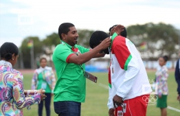 Minister of Sports Ahmed Mahloof giving the Bronze medal to Maazin for 100m Paralympic event. PHOTO: MOC / MOHAMED SHARUAAN WAHEED
