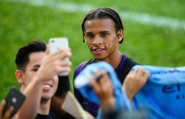 English Premier League Manchester City player Leroy Sane (C) takes a selfie with a fan after a team training session in Hong Kong on July 23, 2019, a day before their match against local team Kitchee. (Photo by ANTHONY WALLACE / AFP)