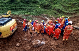 This photo taken on July 24, 2019 shows rescuers working at the site of a landslide in Liupanshui in China's southwestern Guizhou province. - The death toll in a landslide that buried a village in southwest China rose to 20 on July 26, with 25 people still missing three days after the disaster, state media said. (Photo by STR / AFP) / 