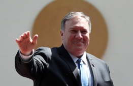 US Secretary of State Mike Pompeo waves at the press next to Salvadorean President Nayib Bukele (out of frame) upon arrival for a meeting at the presidential residence in San Salvador on July 21, 2019. (Photo by MARVIN RECINOS / AFP)