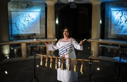 Bulgarian singer Smilyana Zaharieva performs next to a chain of Bulgarian traditional bells, called "chanove", during an interview with AFP in a dome-shaped hall in the village of Starosel, on July 8, 2019. - Smilyana Zaharieva knew she had a gift when she would see her audiences tremble or cry during her performances. Now an official Guinness record confirms that the Bulgarian singer has one of the world's most powerful voices, being able to hit notes comparable to the decibels of a rock concert. (Photo by Dimitar DILKOFF / AFP)