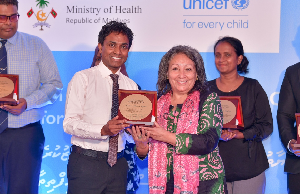 މާލެ- އޮގަސްޓް 1، 2019-: ތުއްތުކުއްޖާގެ ހަޔާތުގެ ފުރަތަމަ 1000 ދުވަހަށް އަމާޒުކޮށްގެން ޔުނިސެފާ ގުޅިގެން ތައްޔާރުކުރި "ސޯޝަލް އެންޑް ބިހޭވިއާ ޗޭންޖް ކޮމިއުނިކޭޝަން ސްޓްރެޓަޖީ" އިފުތިތާހު ކުރަން ބޭއްވި ރަސްމިއްޔާތުގައި، ޔުނިސެފުން ދެކުނު އޭޝިޔާއަށް ކަނޑައަޅާފައިވާ ޑިރެކްޓަރު ޖީން ގޮގް ޕްރޮފެސަރު އުގެއިލް އަށް އެވޯޑު ހަވާލު ކޮށްދެއްވަނީ-- ފޮޓޯ:ނިޝާން އަލީ/މިހާރު