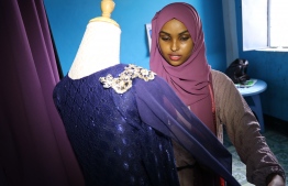 Hawa Adan Hassan, a 23 year-old university student and a young Somali female fashion designer checks her new finished fashion design, on November 3, 2018, in Mogadishu. - Somalia's clothes business is a simple one: foreign imported garments for the well-to-do, locally tailored clothes for the rest. But new fashion designers are complicating that picture with locally-designed, hand-made attire. (Photo by Abdi HAJJI HUSSEIN / AFP)