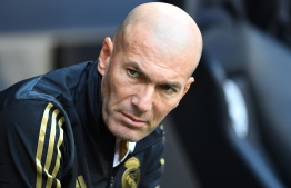 Real Madrid's French coach Zinedine Zidane waits ahead the Audi Cup football match between Real Madrid and Tottenham Hotspur in Munich, on July 30, 2019. (Photo by Christof STACHE / AFP)